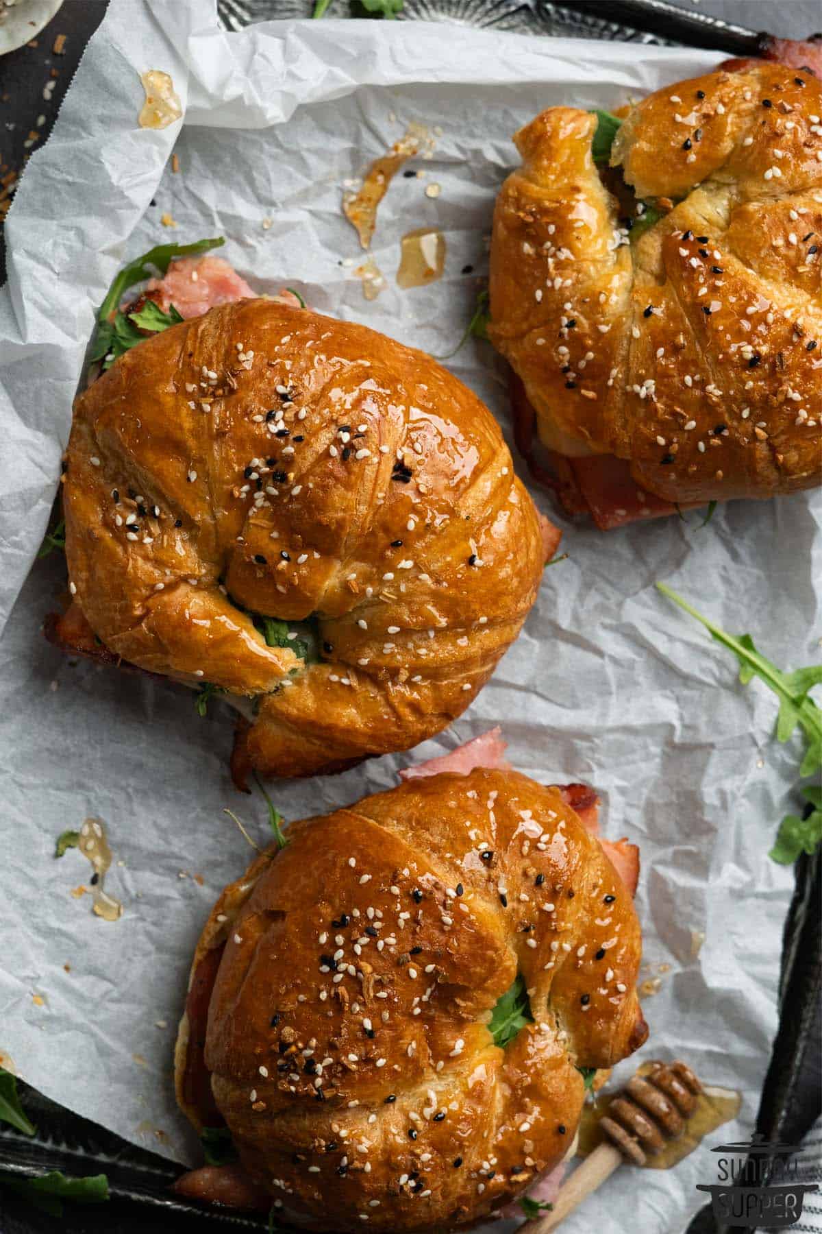 3 ham and cheese croissants on parchment paper