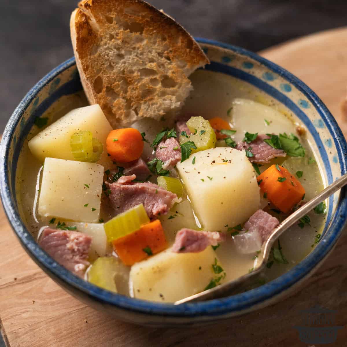 ham bone soup in a bowl with a piece of bread