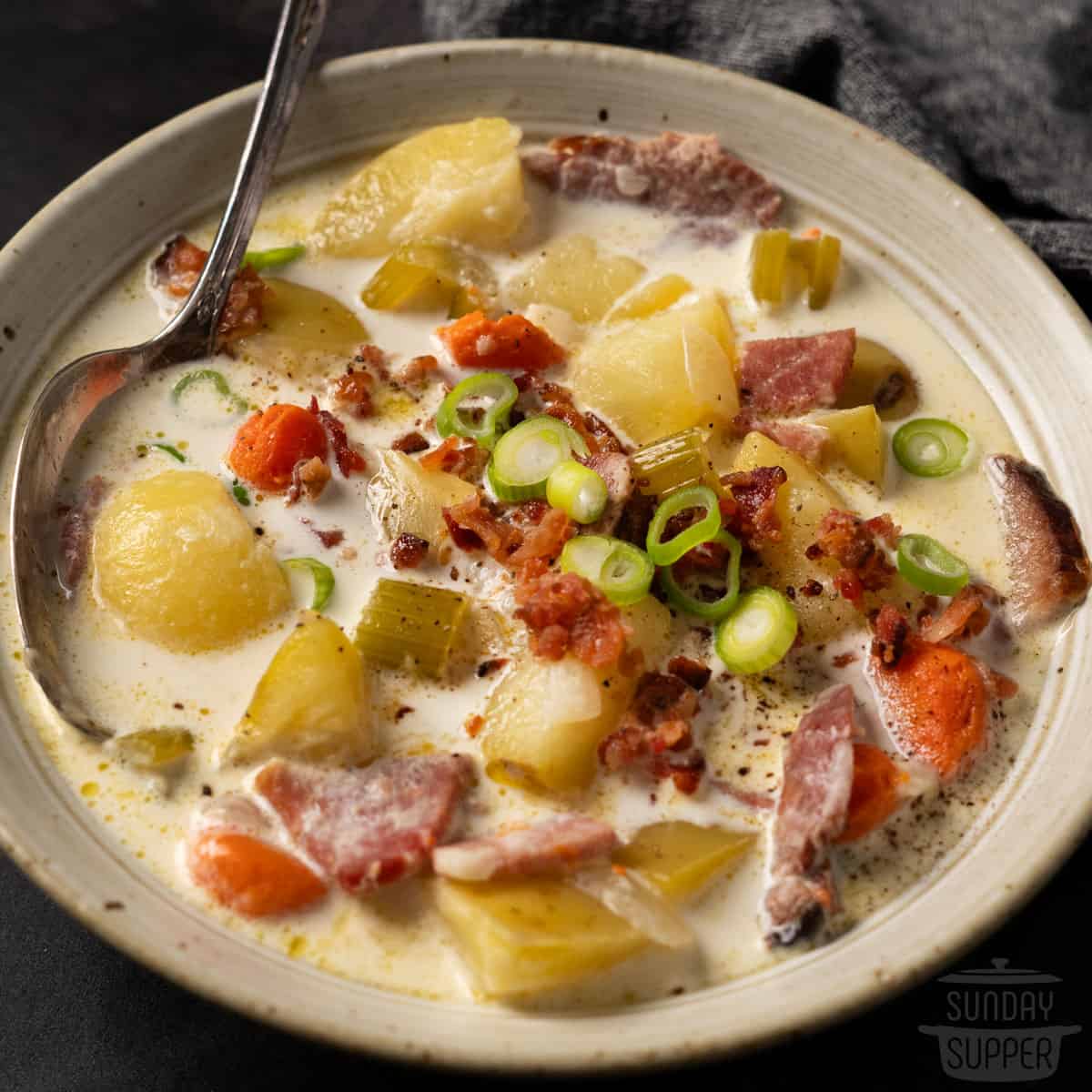 close up of ham soup in a bowl with a spoon inside of the bowl