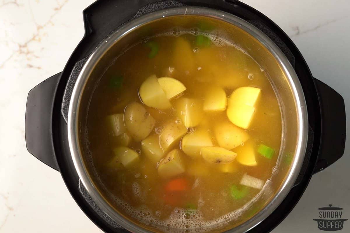 adding broth and potatoes to the instant pot
