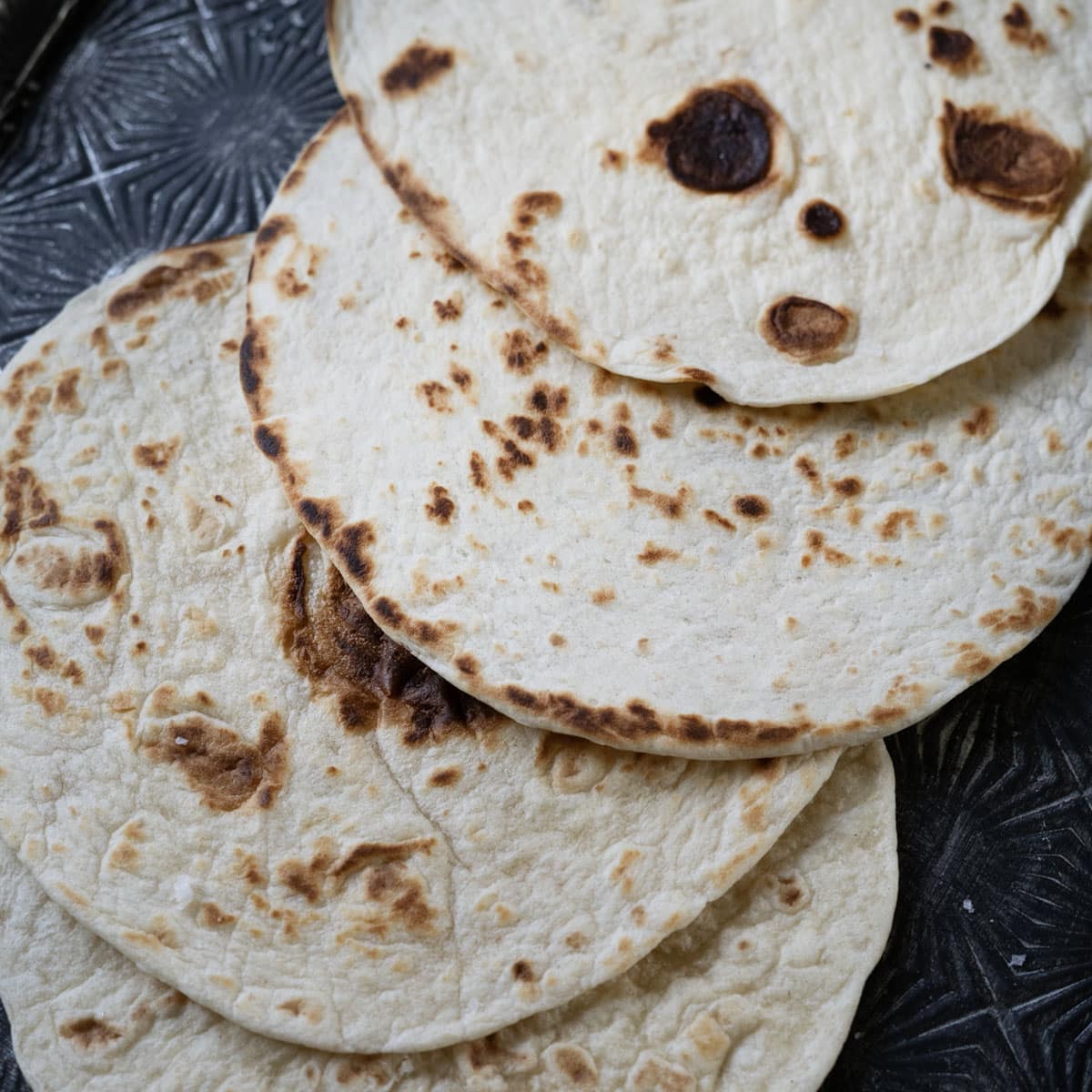 a set of warm tortillas on a platter