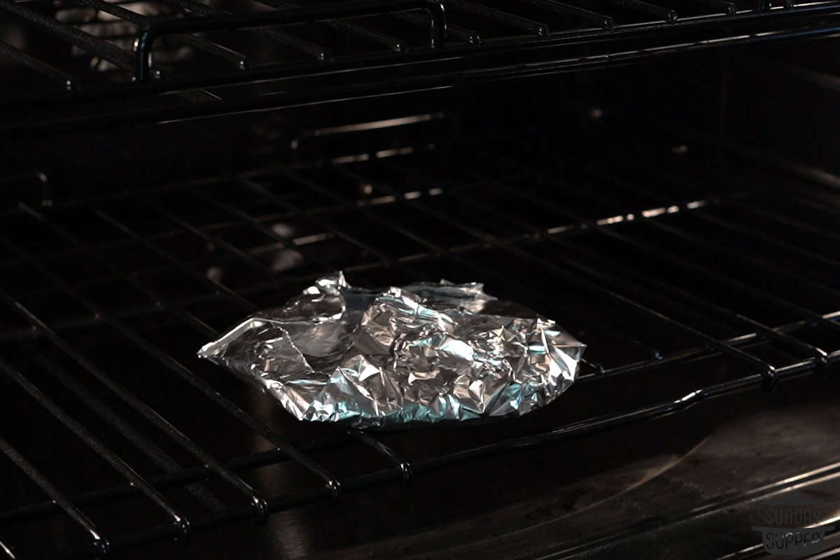 foil wrapped tortillas placed in the oven on an oven rack