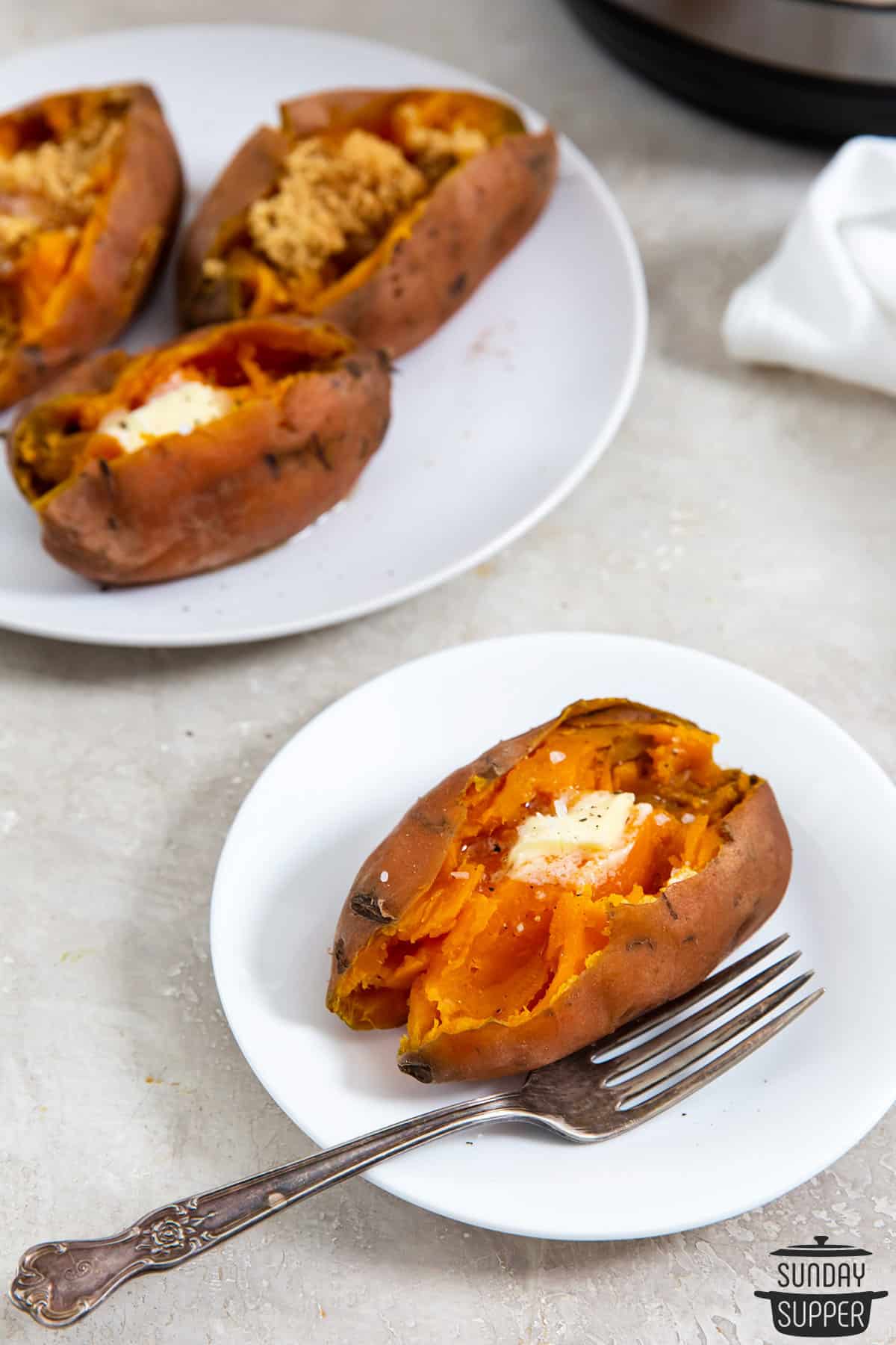 a cooked sweet potato on a plate with butter and salt