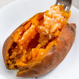a fork full of sweet potato on a plate