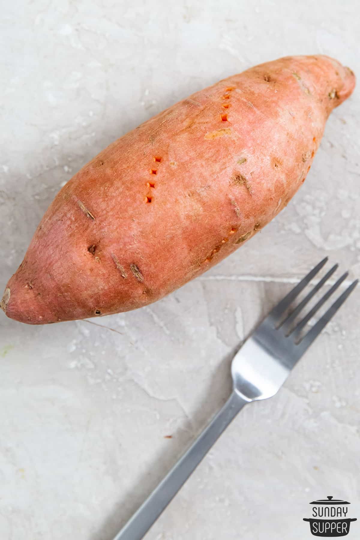 a sweet potato stabbed multiple times with a fork