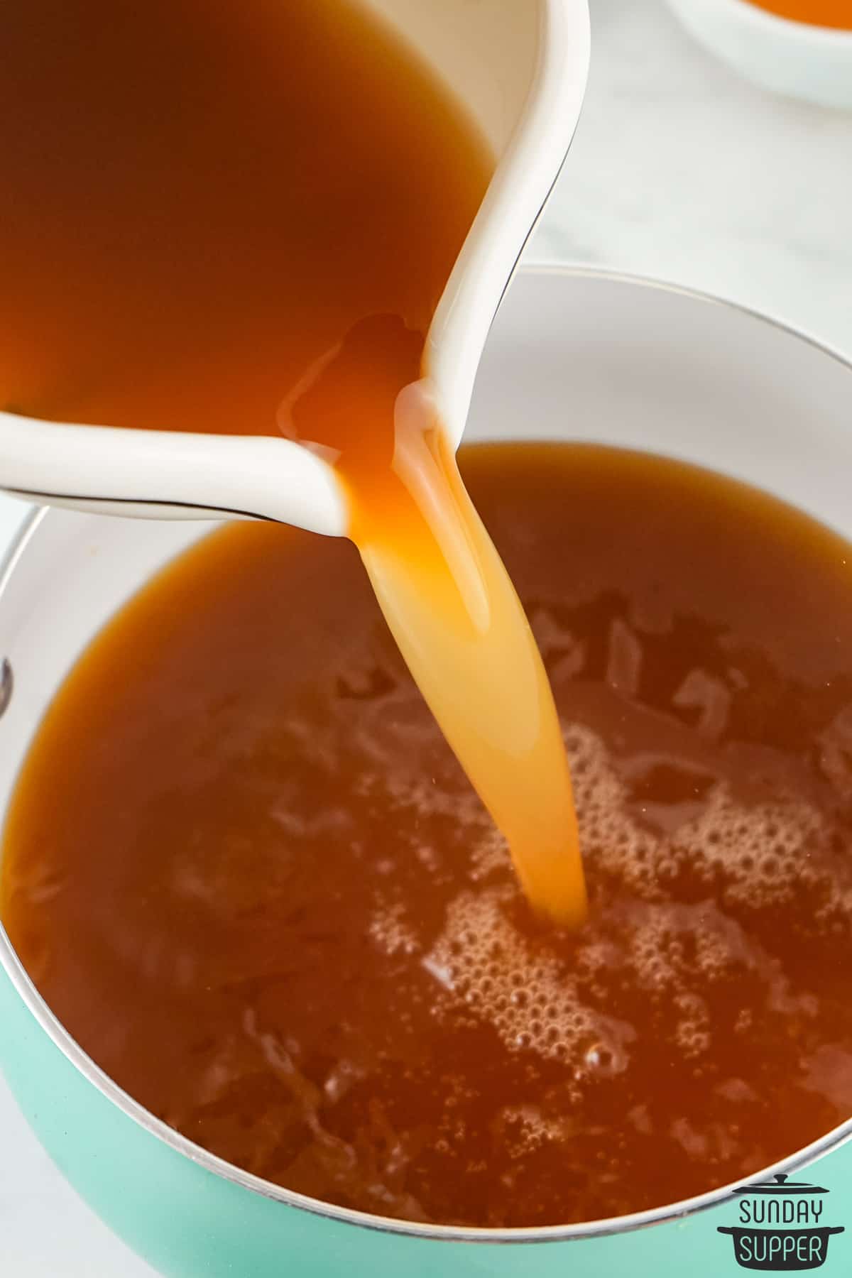 vinegar and brown sugar being poured into a pan
