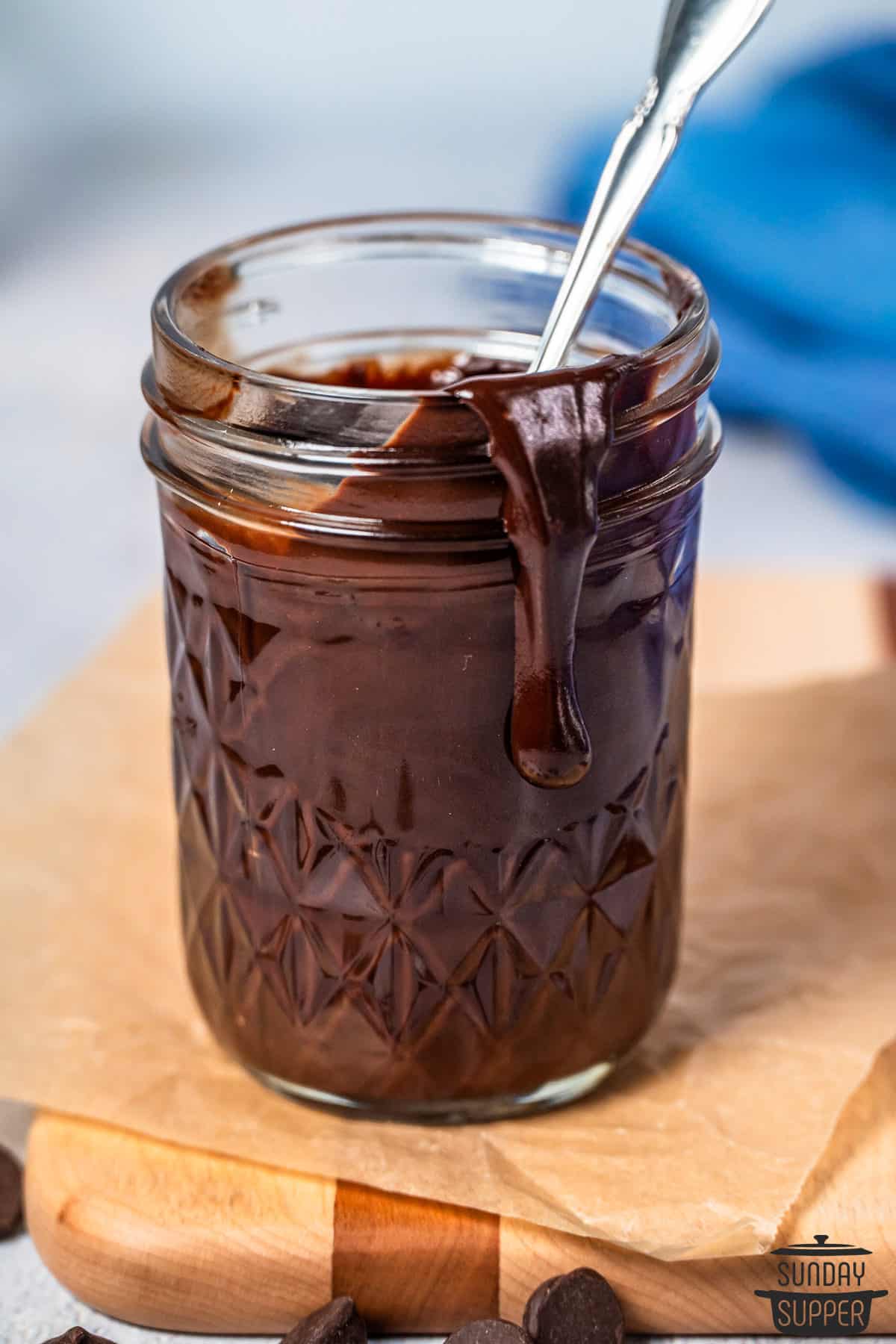 chocolate sauce poured into a glass jar with a spoon