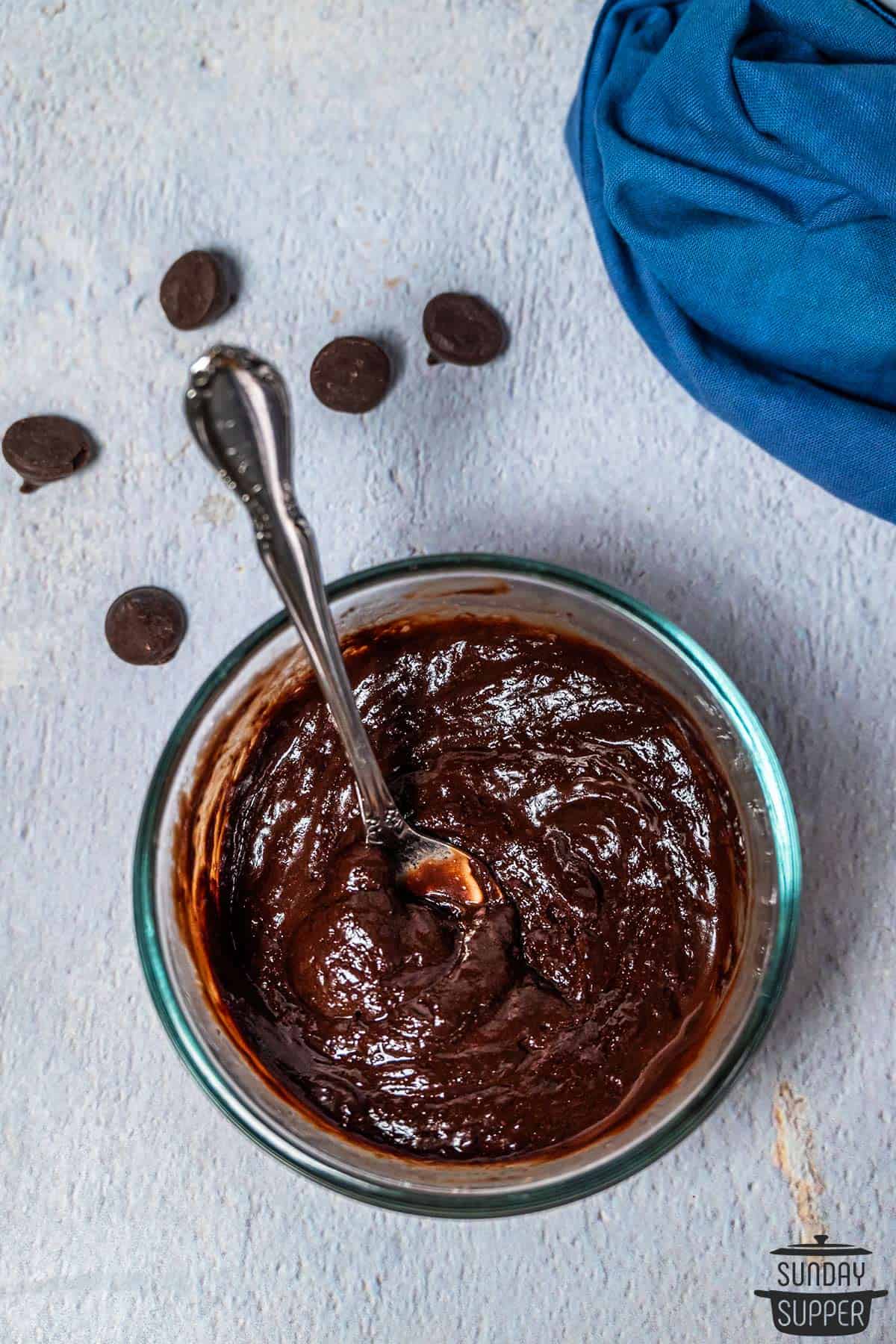 partially melted chocolate sauce in a bowl with a spoon