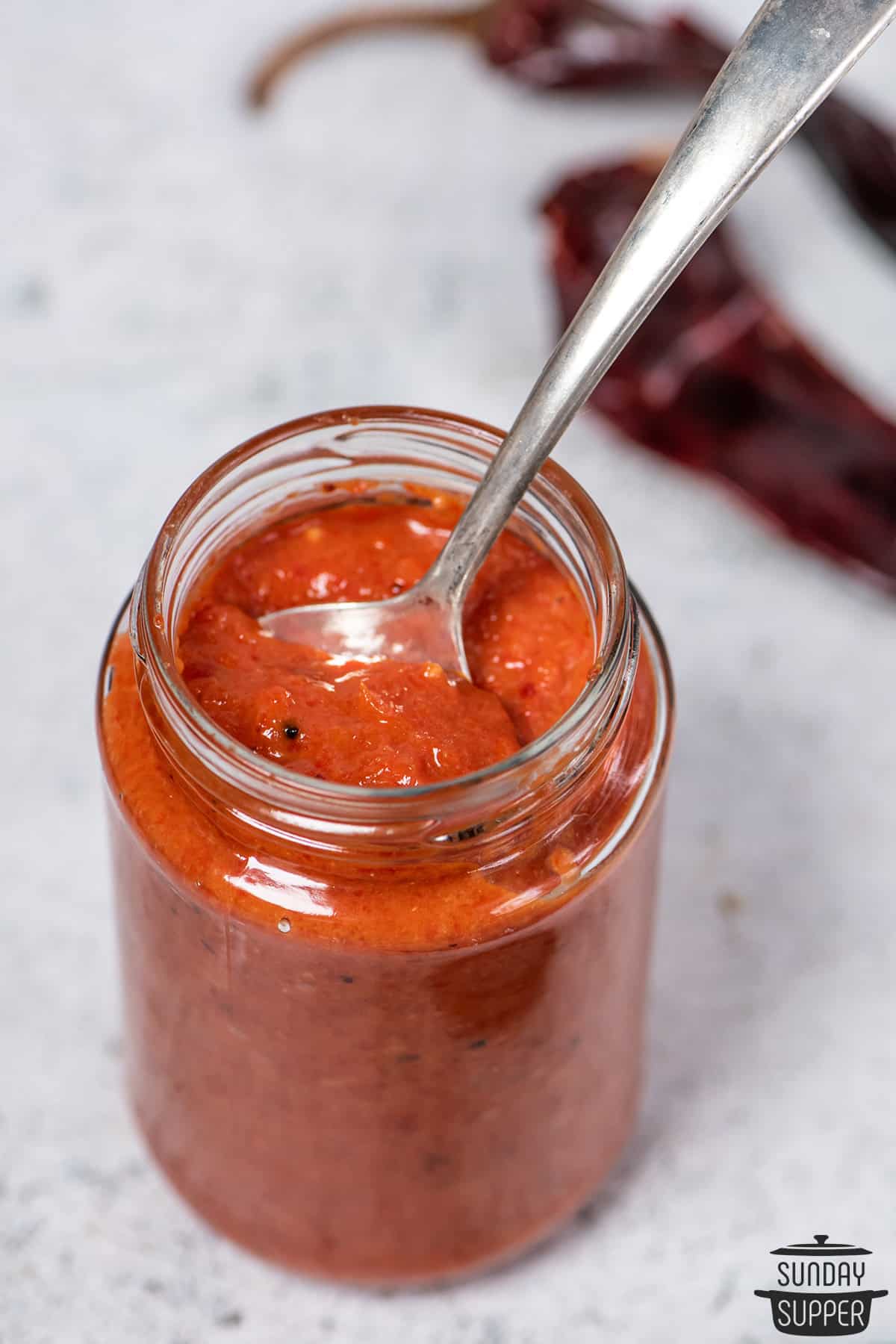 harissa sauce in a jar with a spoon