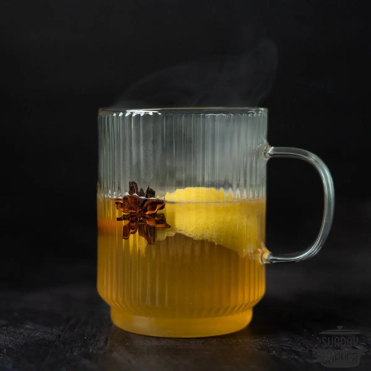 a hot toddy in a glass with steam rising off the top