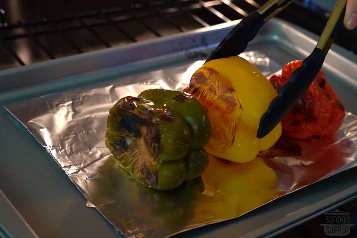 the roast peppers being flipped in the oven