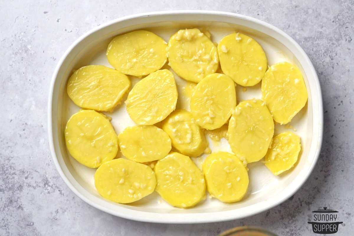 the potato slices in a dish with butter and garlic