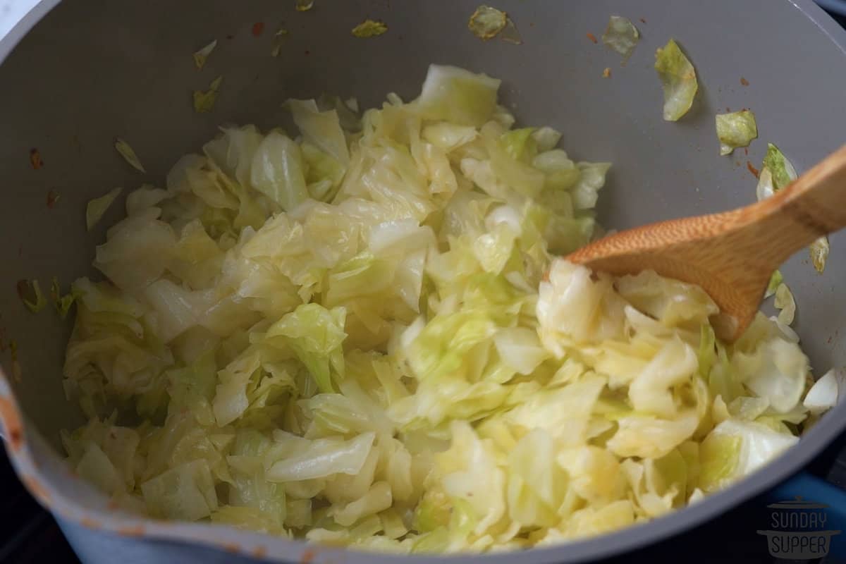 mixing the cabbage mixture as it softens with a wooden spoon