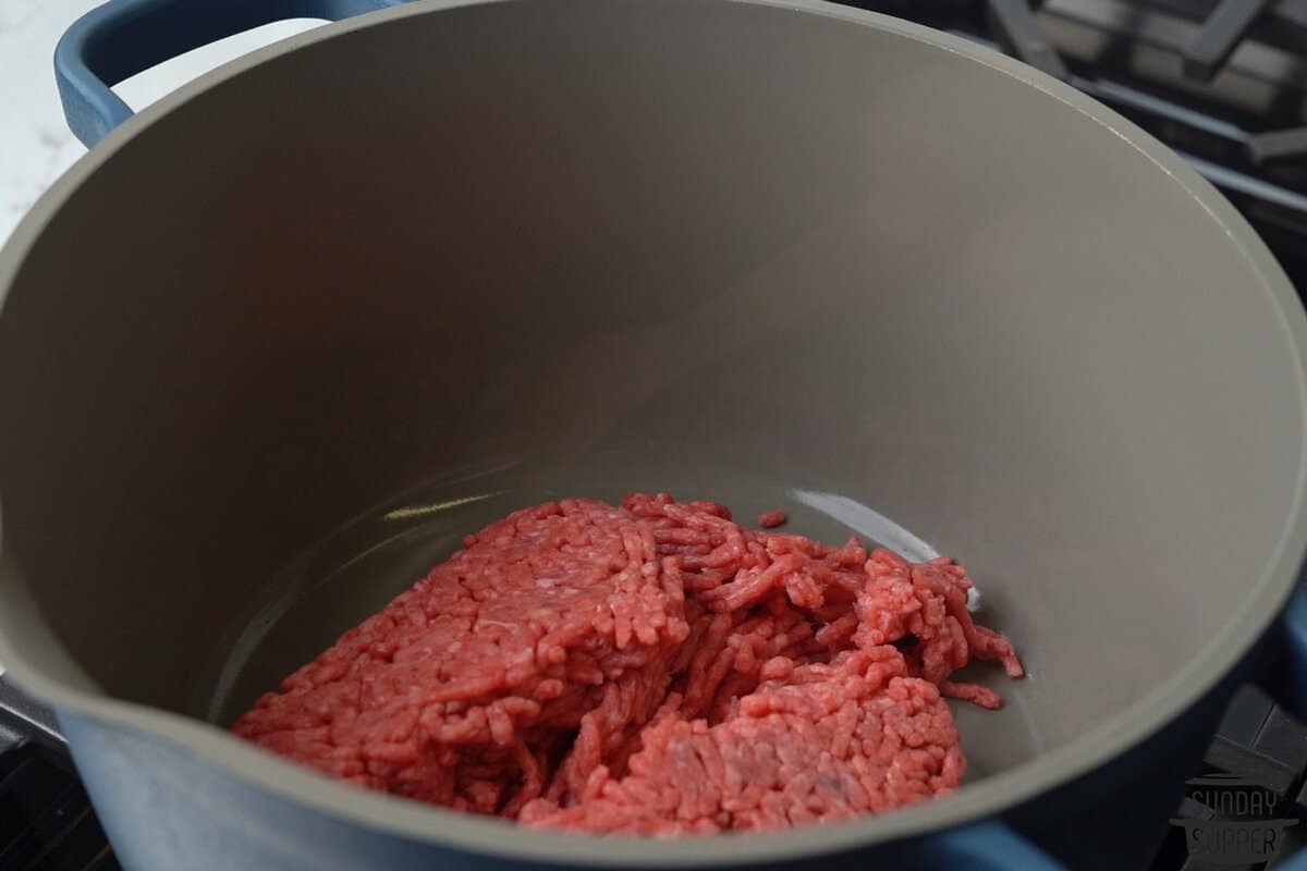 adding ground beef to a pot