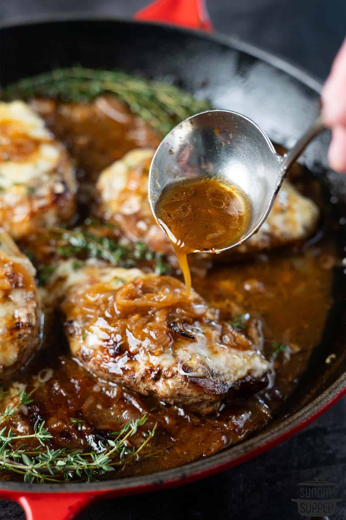pouring sauce over French onion pork chops
