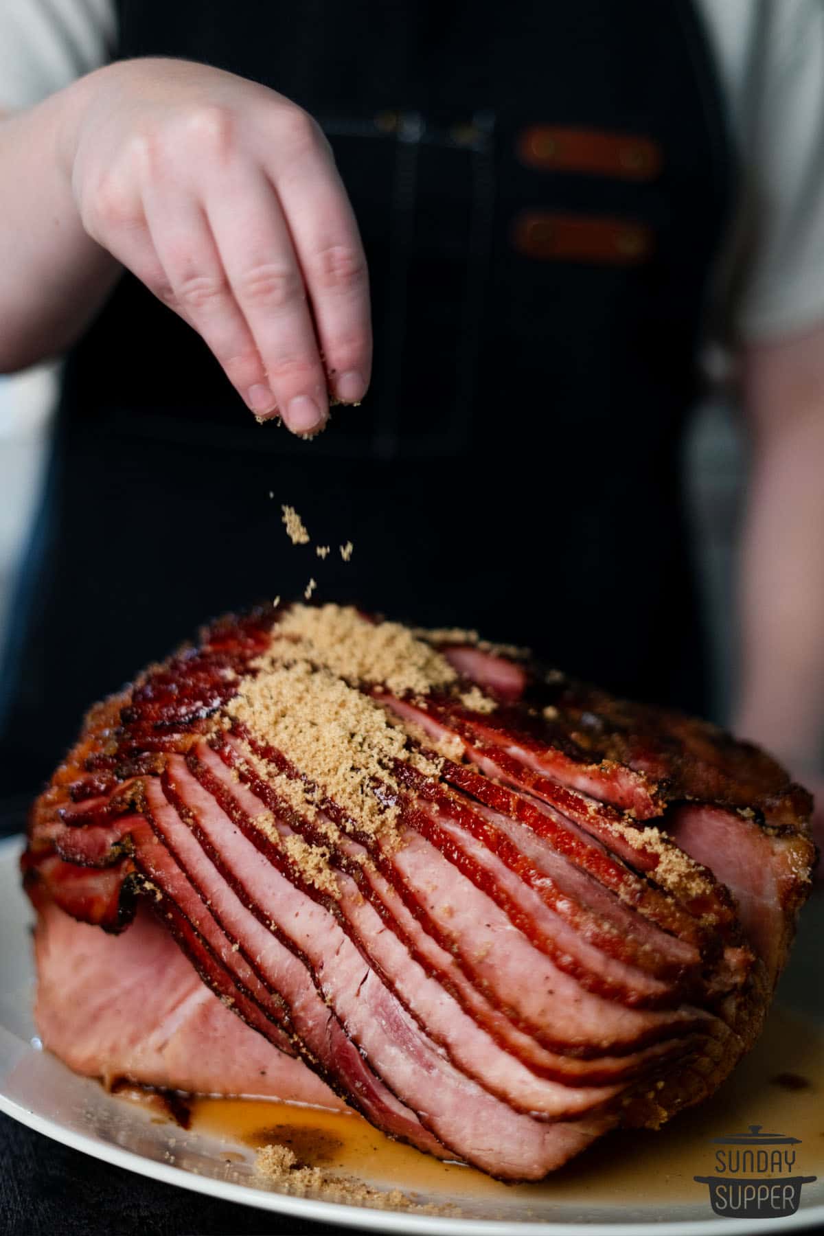sprinkling brown sugar on grilled ham