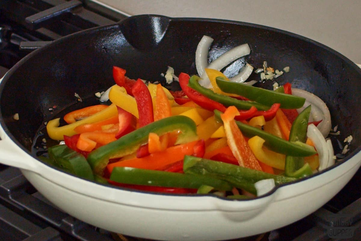 sautéing peppers, onions, and garlic in a skillet