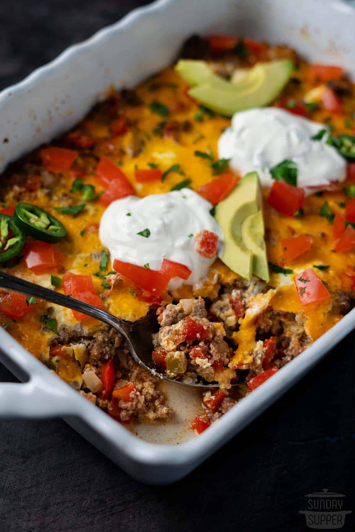 taco casserole in a casserole dish with a spoonful