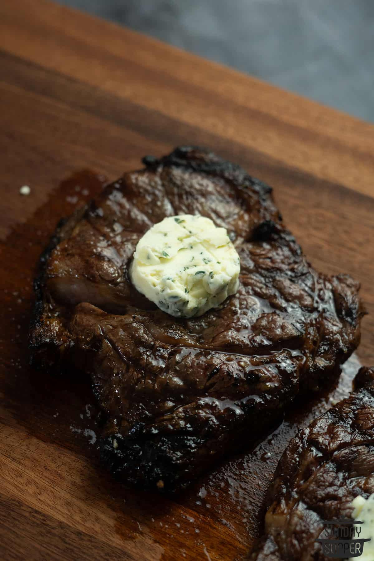 a slice of compound butter on a freshly cooked steak