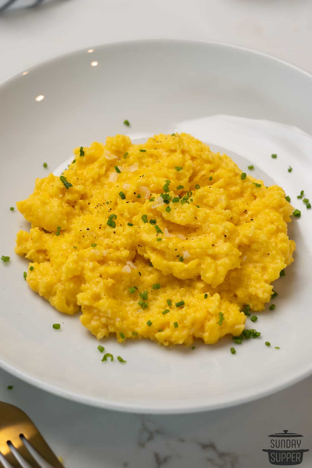 a plate filled with creamy scrambled eggs