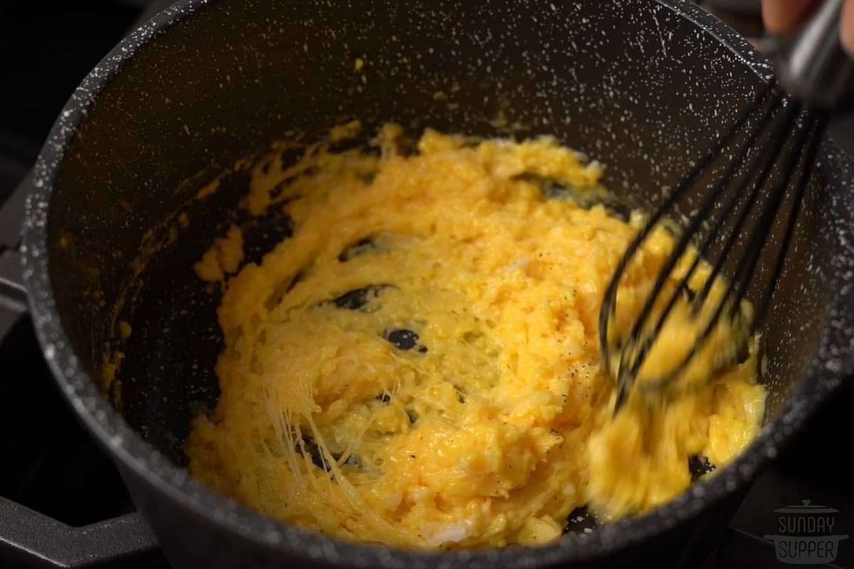 the cheese being mixed into the eggs until melted