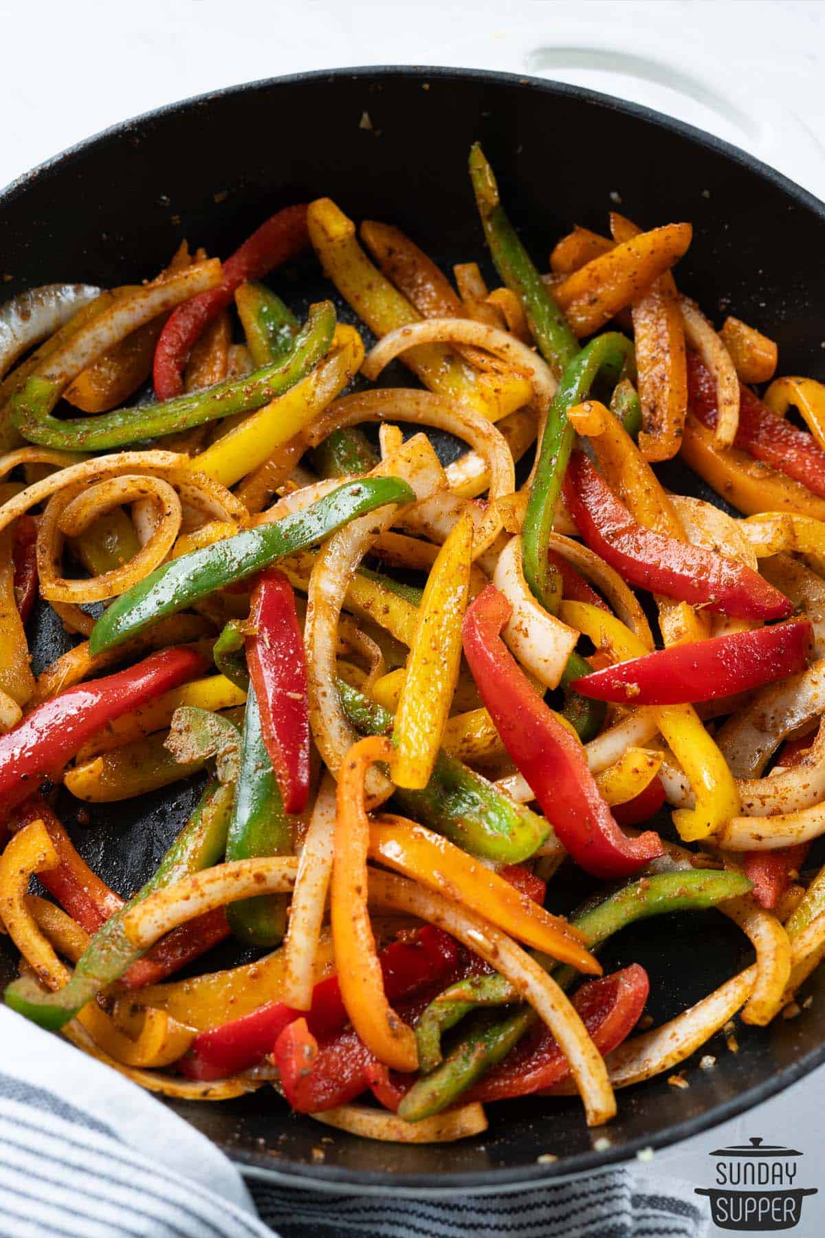 a cast iron pan filled with completed fajita veggies