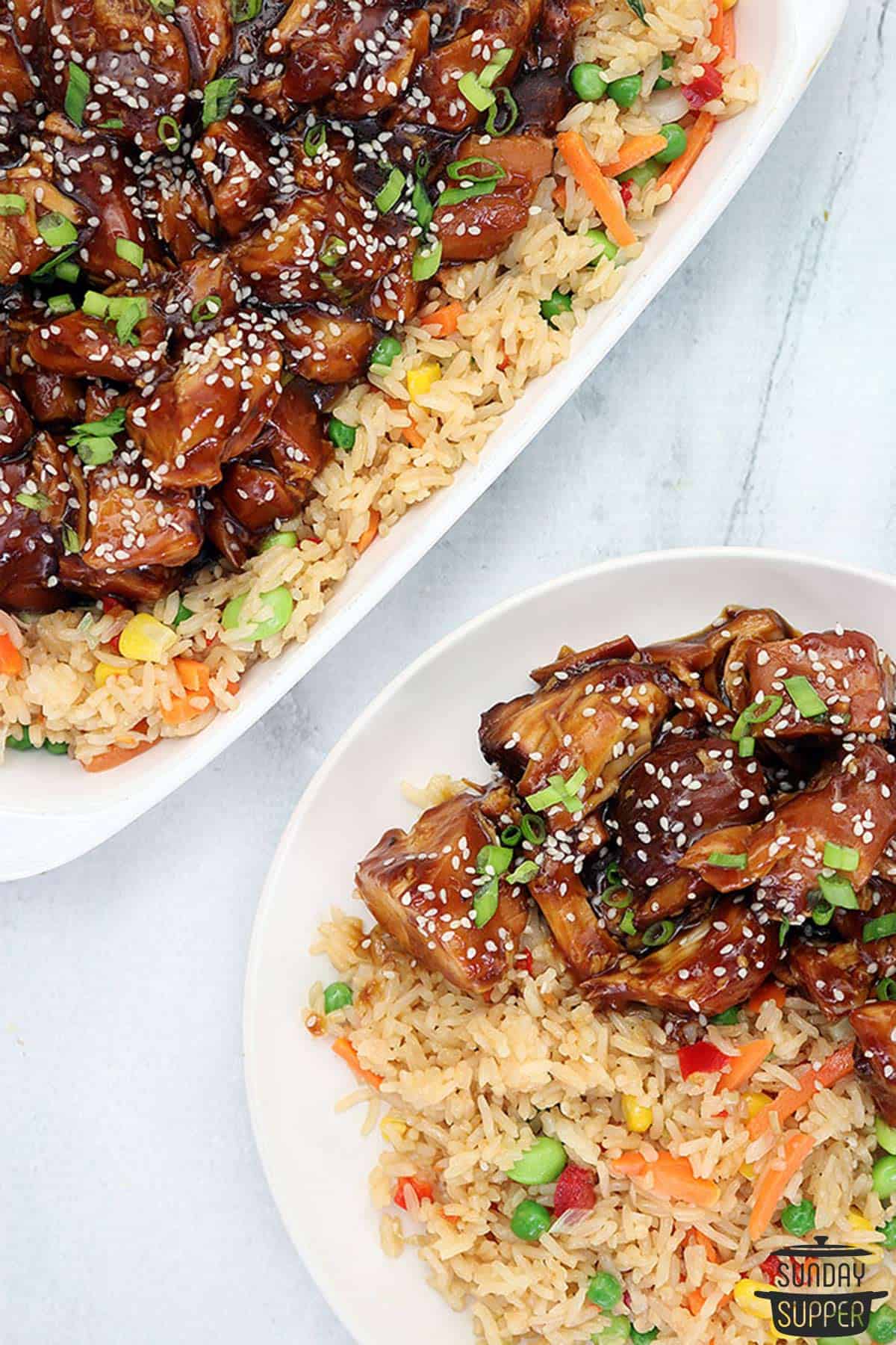 two dinner plates of honey sesame chicken and fried rice
