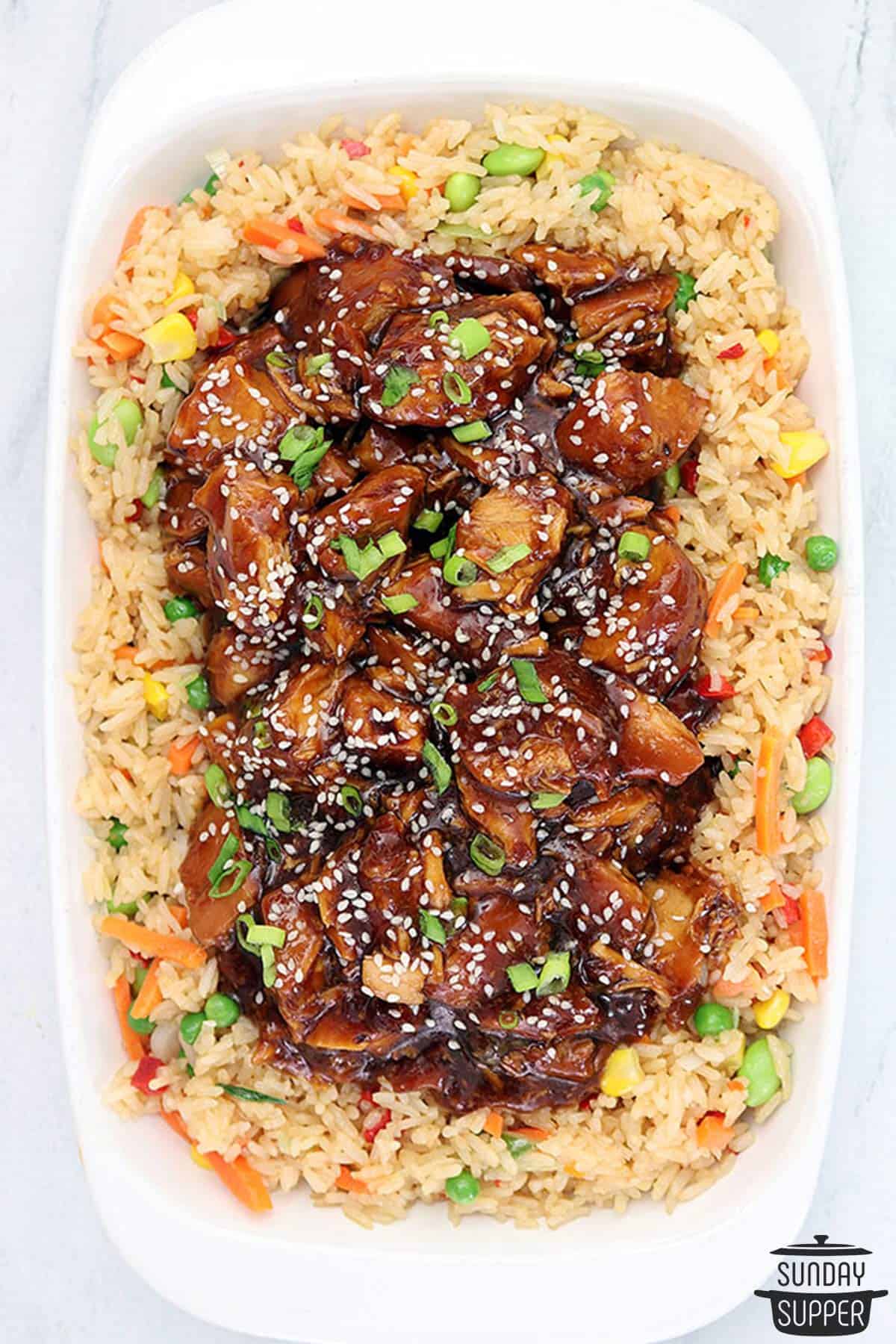 honey sesame chicken on top of a pile of fried rice