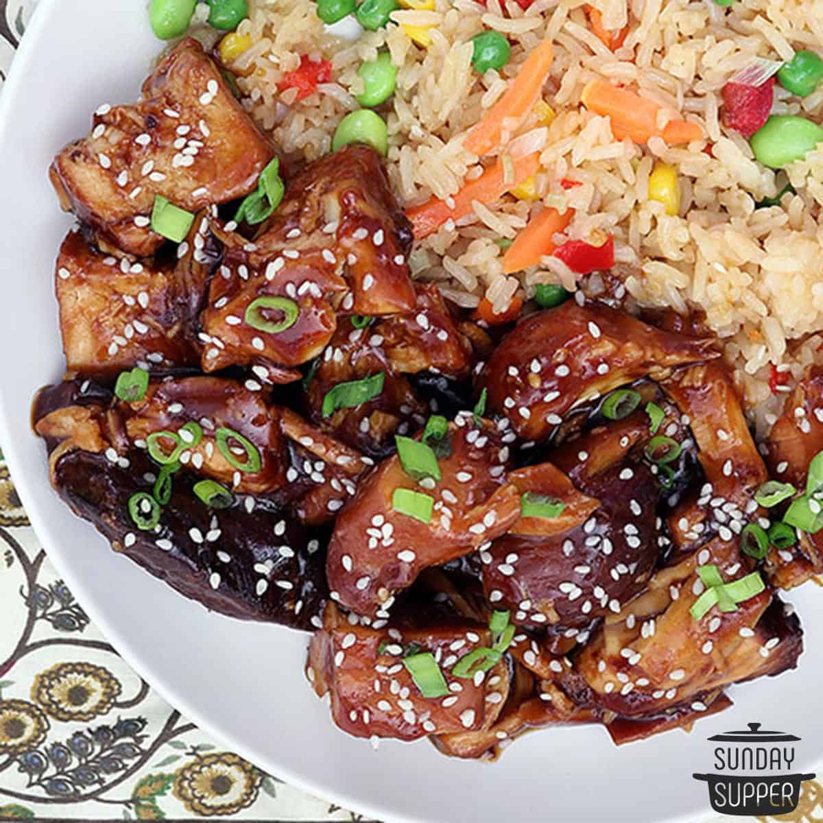a plate of honey sesame chicken with rice