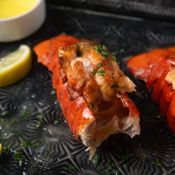 a closeup of an instant pot lobster tail with butter