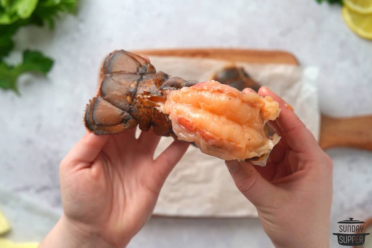 a lobster tail with the meat pulled out to rest on top of the shell