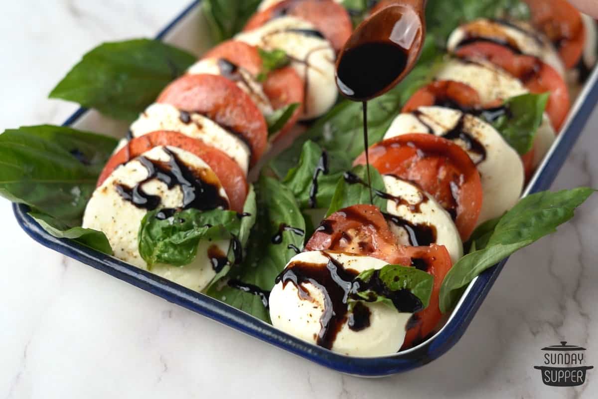 finished balsamic glaze being used to dress a salad