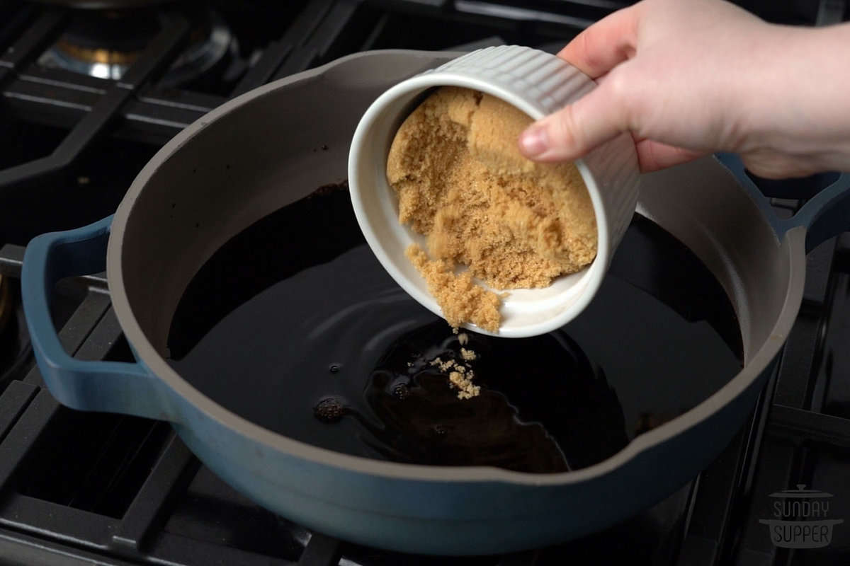 the brown sugar being added to the pot of vinegar