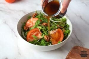 pouring balsamic dressing over salad