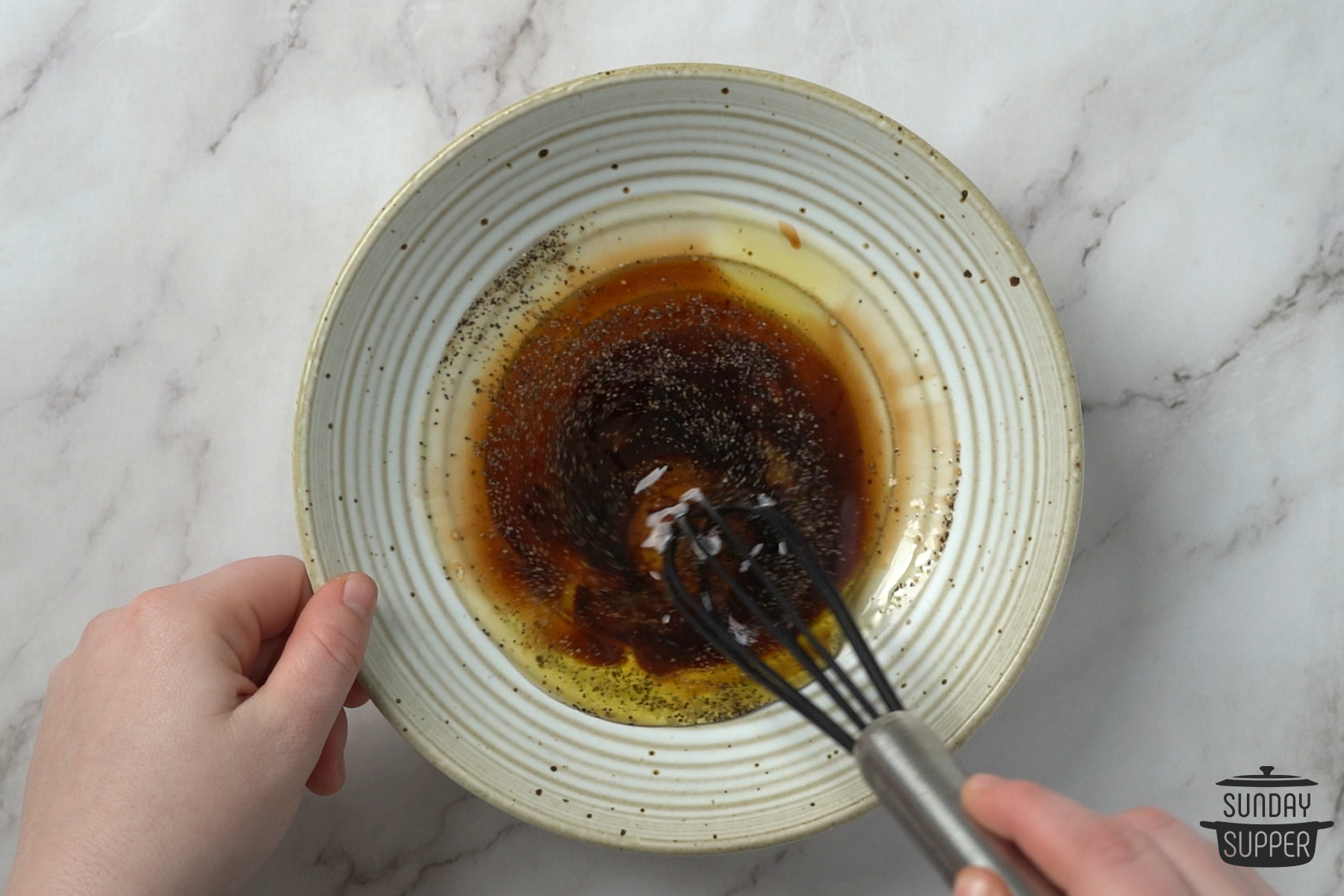whisking together balsamic dressing ingredients in a bowl