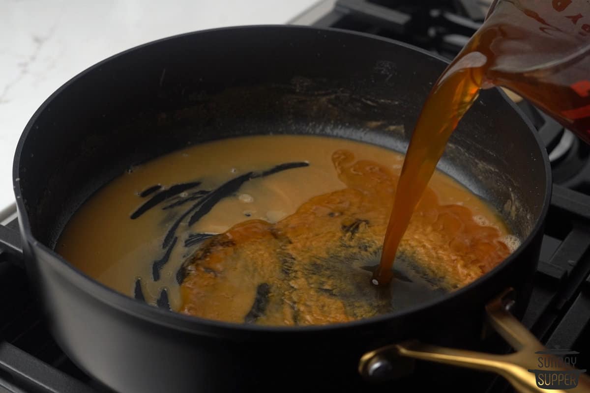 broth and drippings being added to the pan