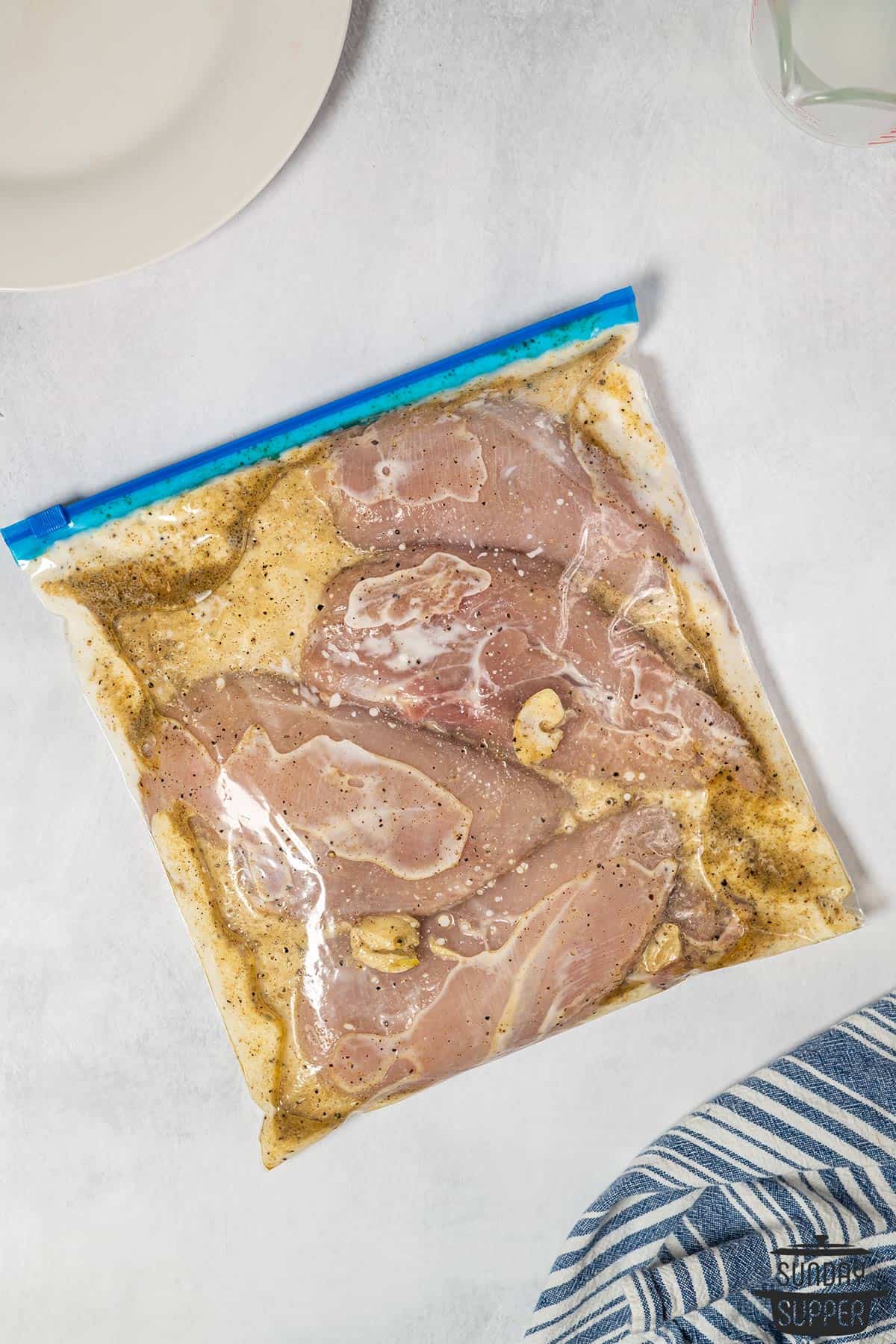 chicken in a plastic bag with buttermilk marinade