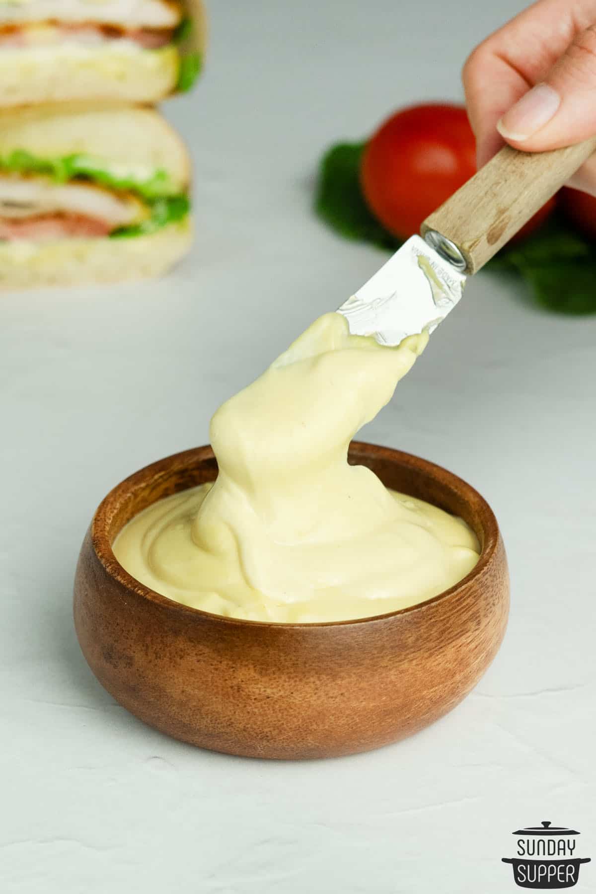 mayo mustard sauce in a wood bowl with a knife inside