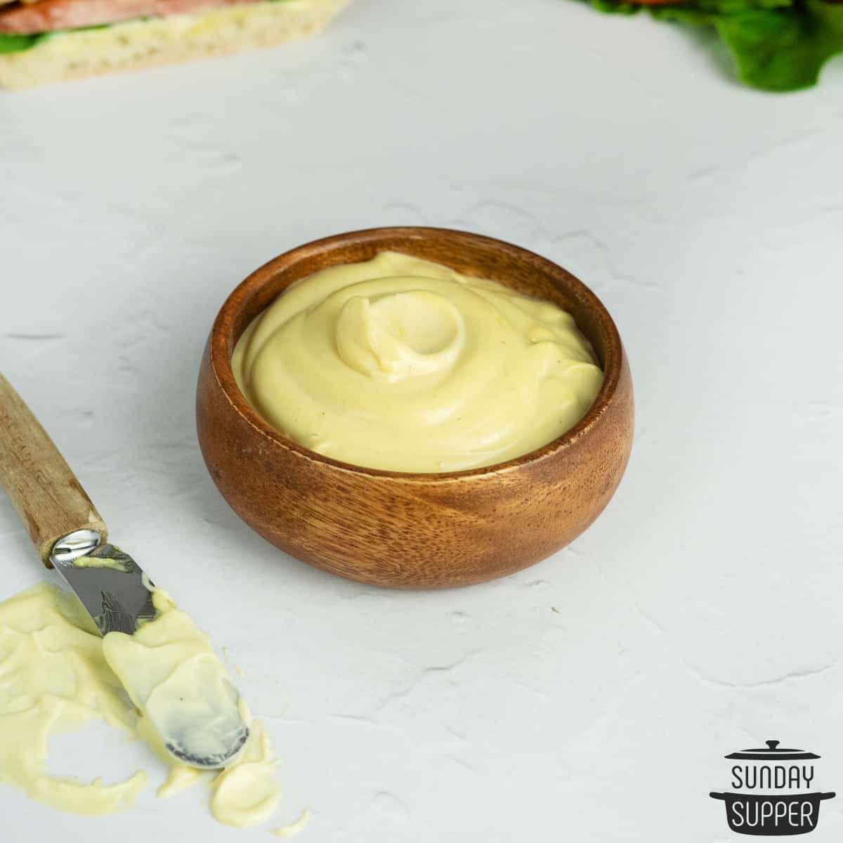 close up of mayo mustard sauce in a wood bowl