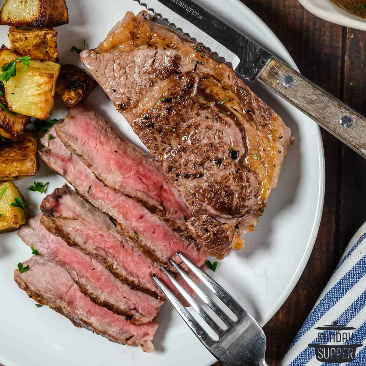 steak sliced on a plate with a fork and knife