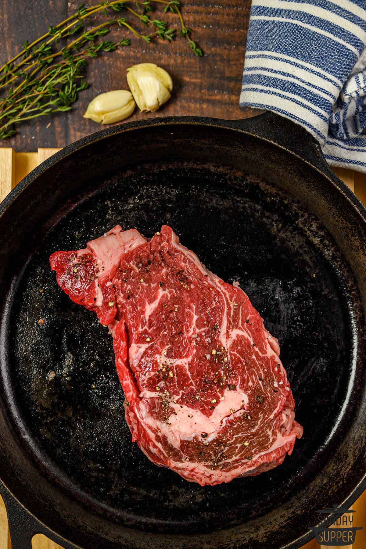 a raw steak on a cast iron pan