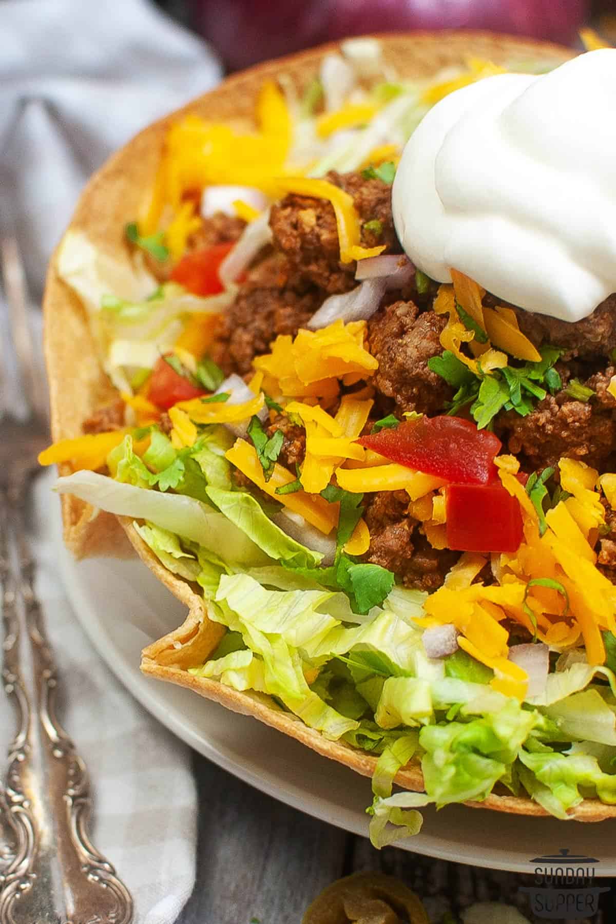 a taco bowl on a plate showing off the crispy edges