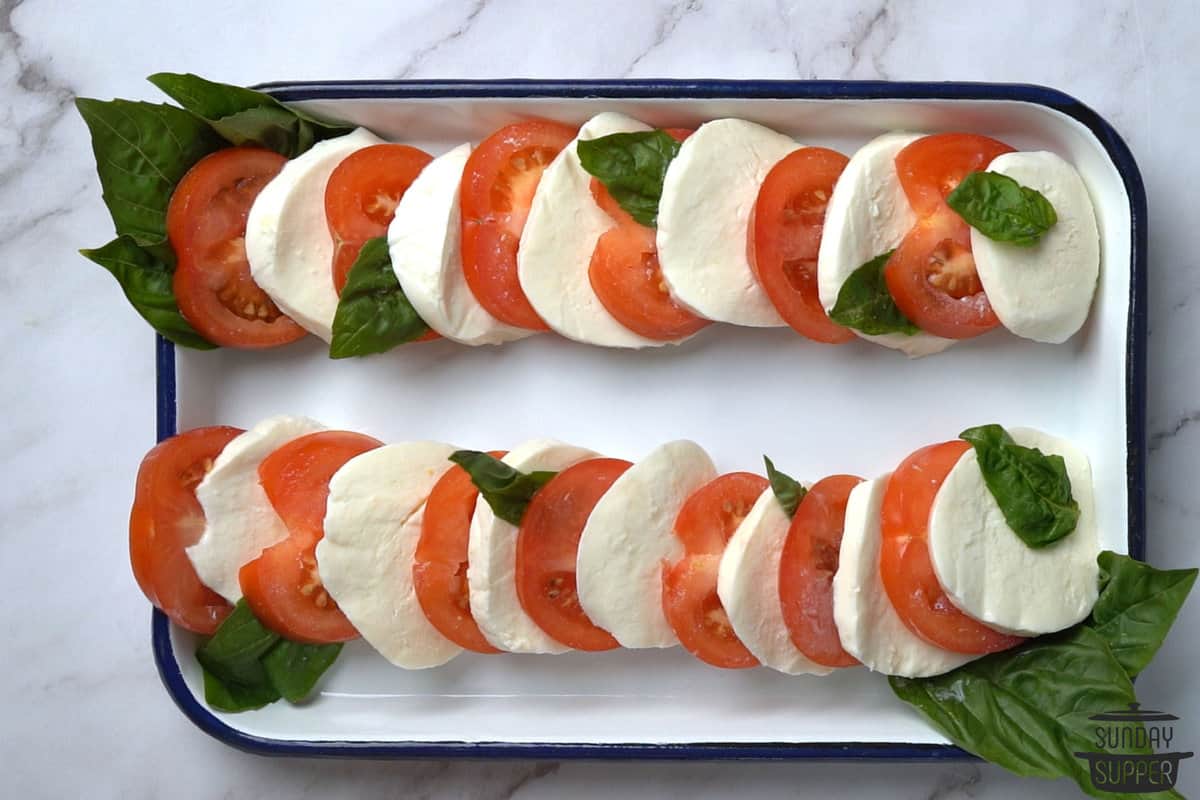 the tomato, mozzarella, and basil layered in alternating order on a serving platter