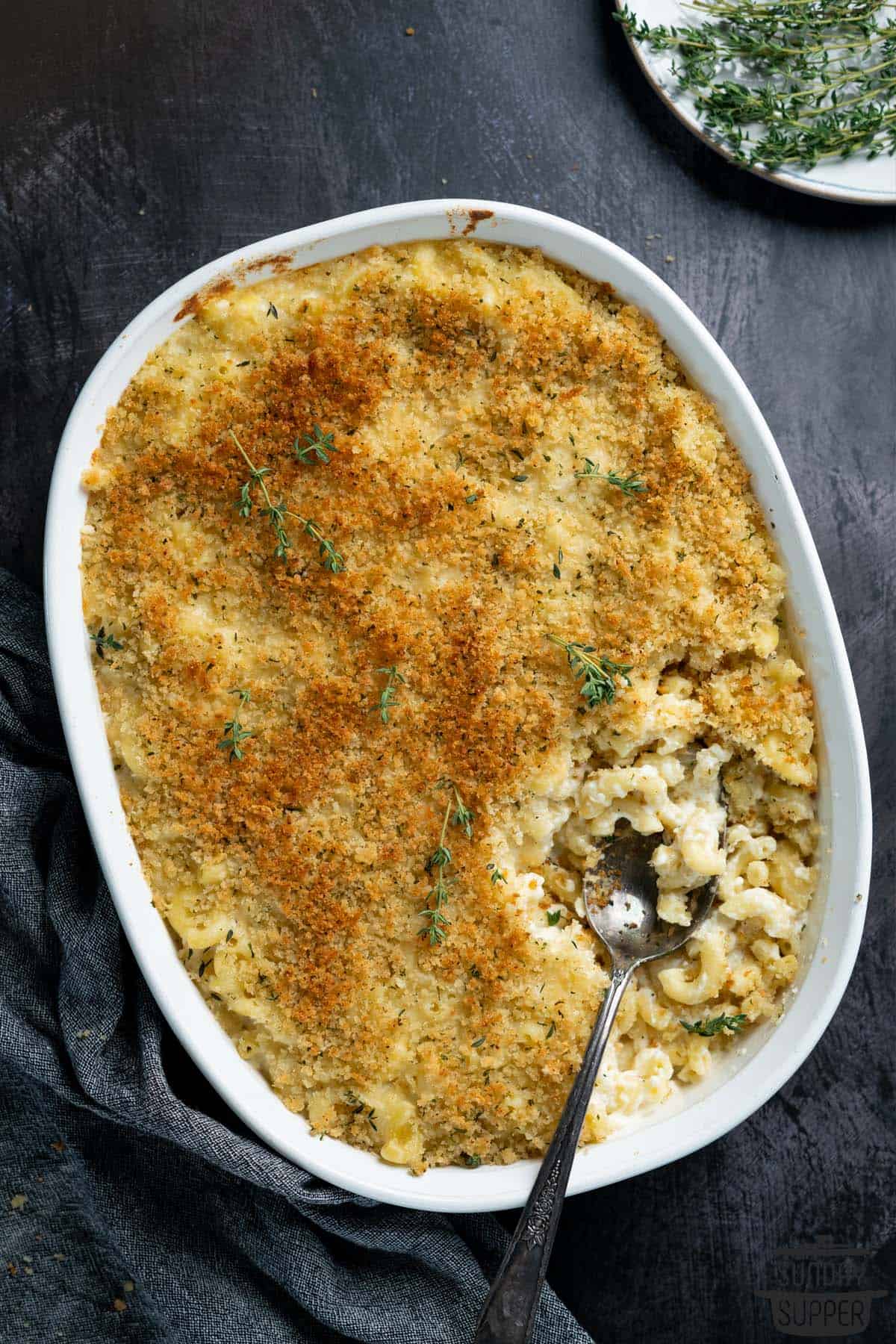 truffle macaroni and cheese in a white casserole dish with a spoon