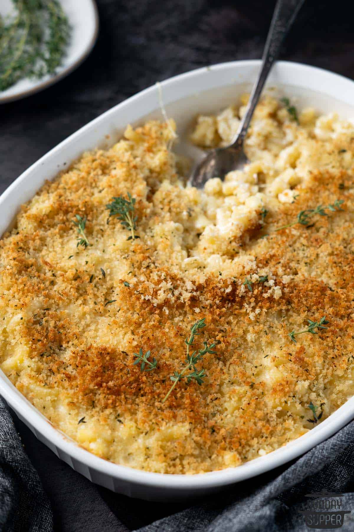 a spoon inside of a casserole dish full of truffle macaroni and cheese