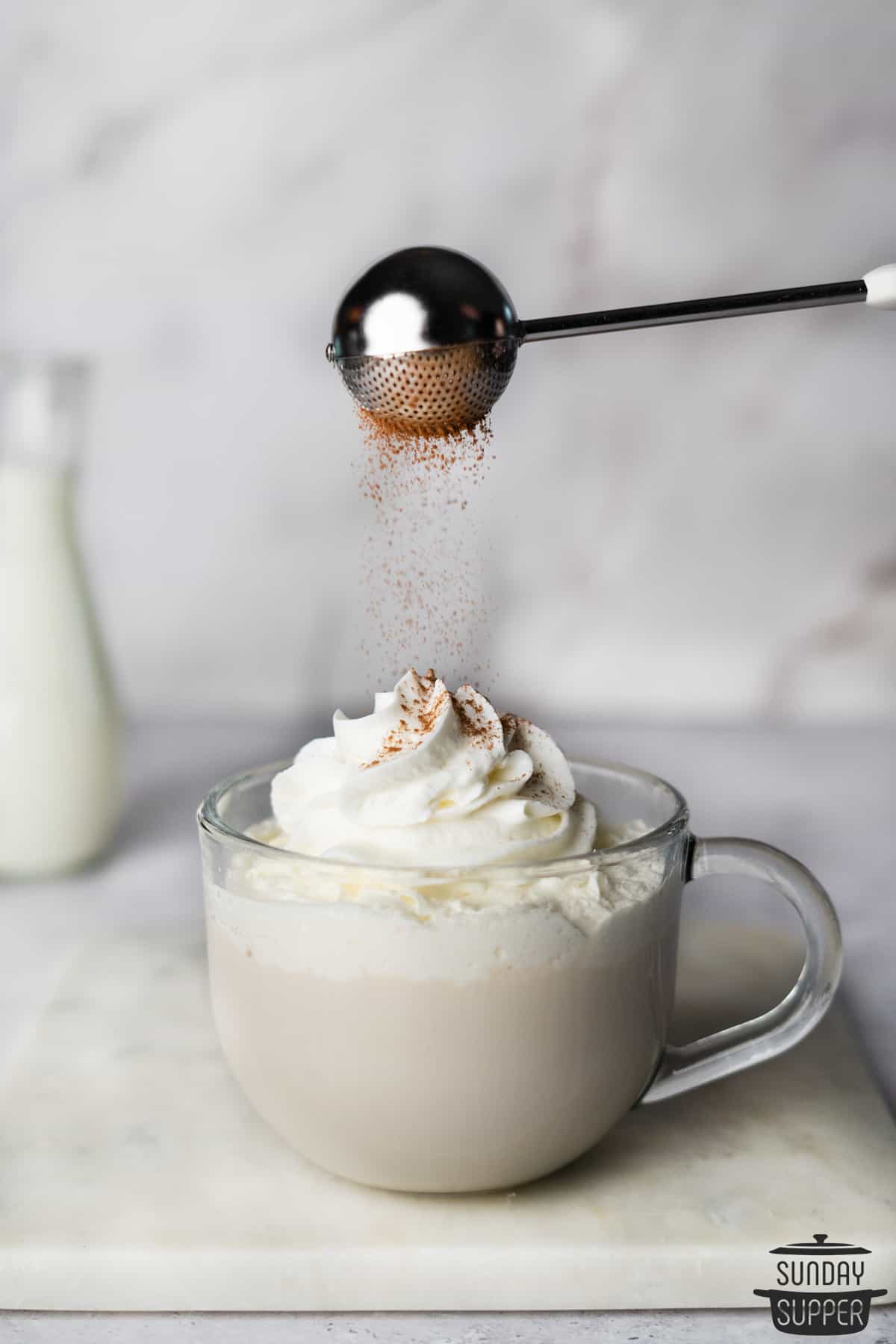 white chocolate mocha in a clear mug with cinnamon on top