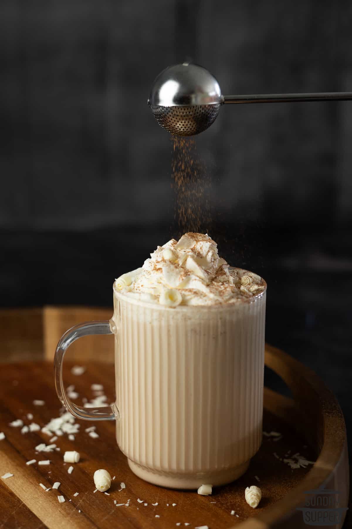 white chocolate mocha in a clear mug with cinnamon on top