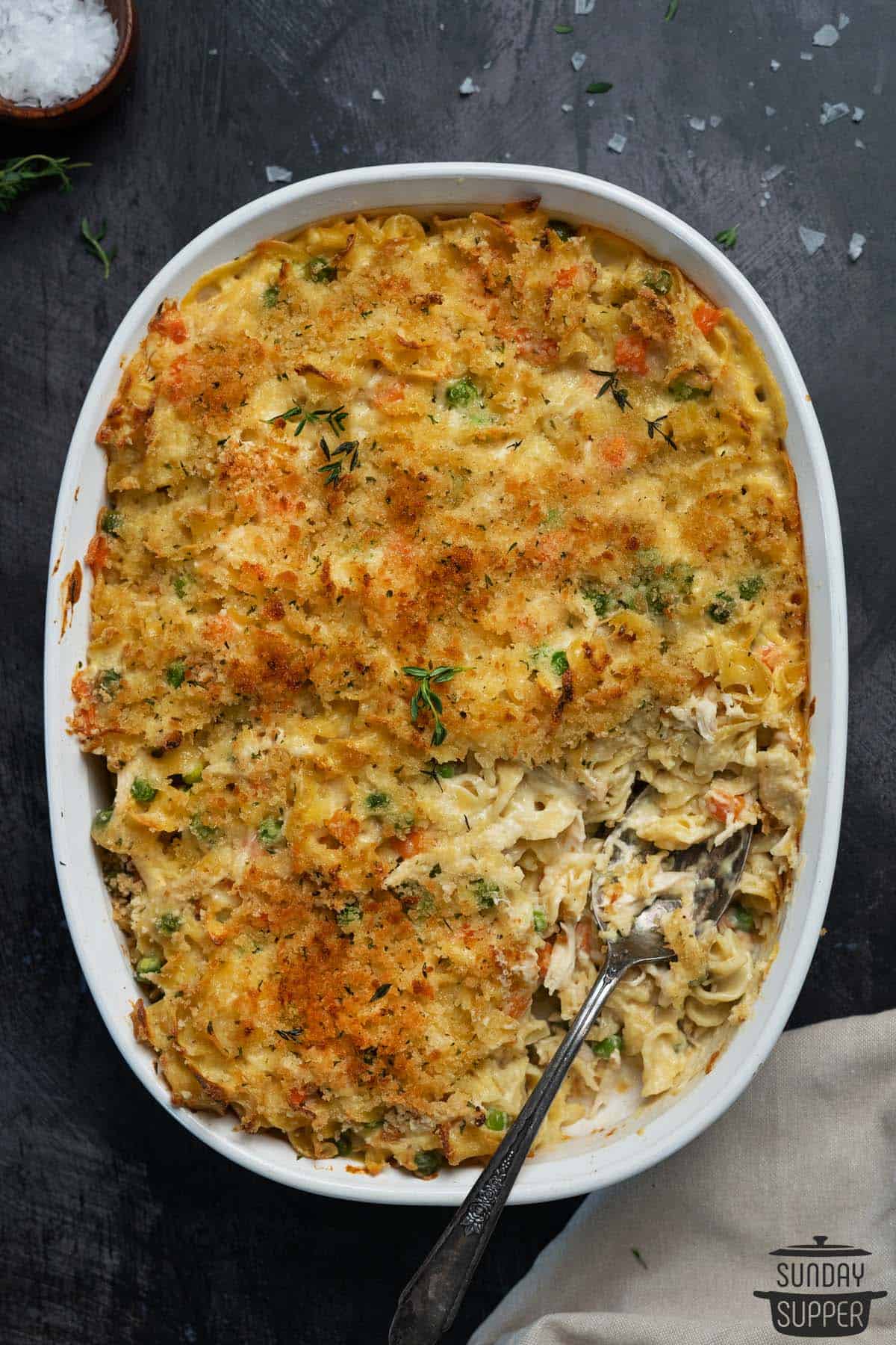 a casserole dish of chicken noodle bake with a spoon