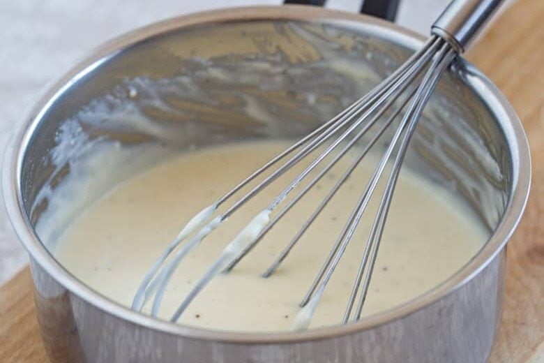Cheese Sauce in a saucepan with a whisk