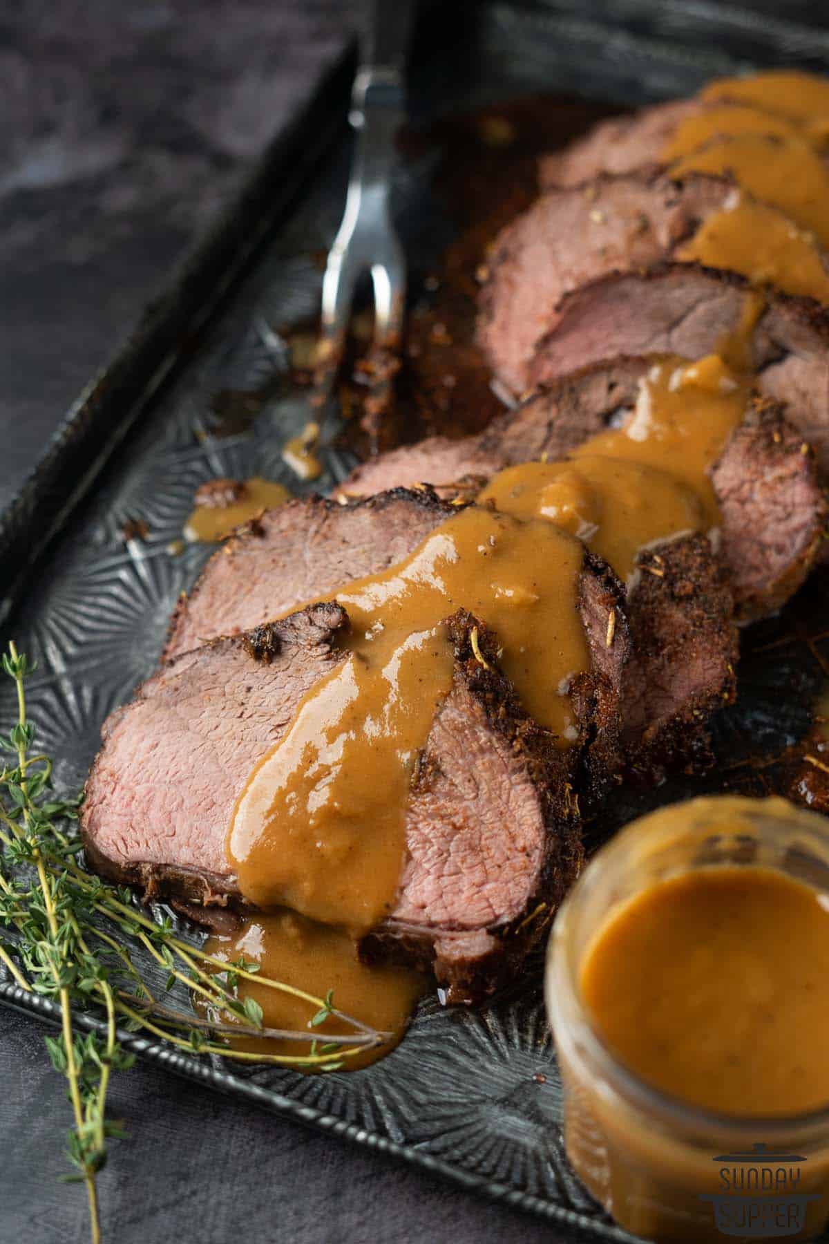 sliced of chuck roast on a platter with gravy
